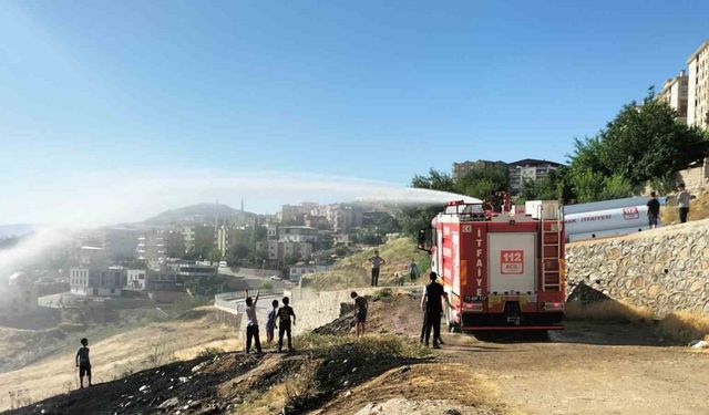 İtfaiyeciler yangın söndürme derdinde, çocuklar serinlemenin keyfinde